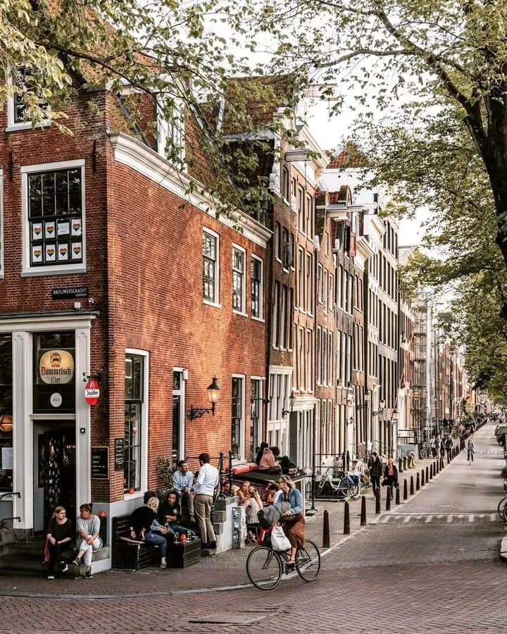 A café corner, bicycles and historic brick houses beside a canal.