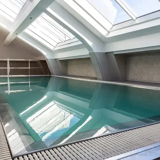 Continental Hotel Budapest’s indoor swimming pool beneath glazed roof panels.
