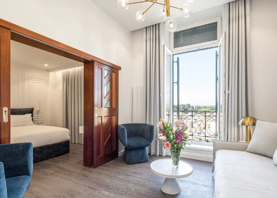 The sitting area and bedroom in Bella Venezia’s Master Suite, with blue chairs and a sofa.
