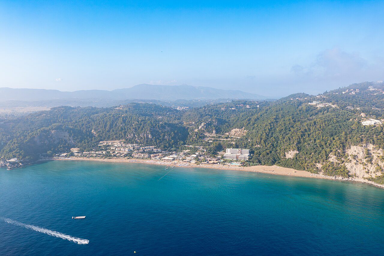 An aerial view of Glyfada’s sandy bay below wooded hills on Corfu’s west coast.