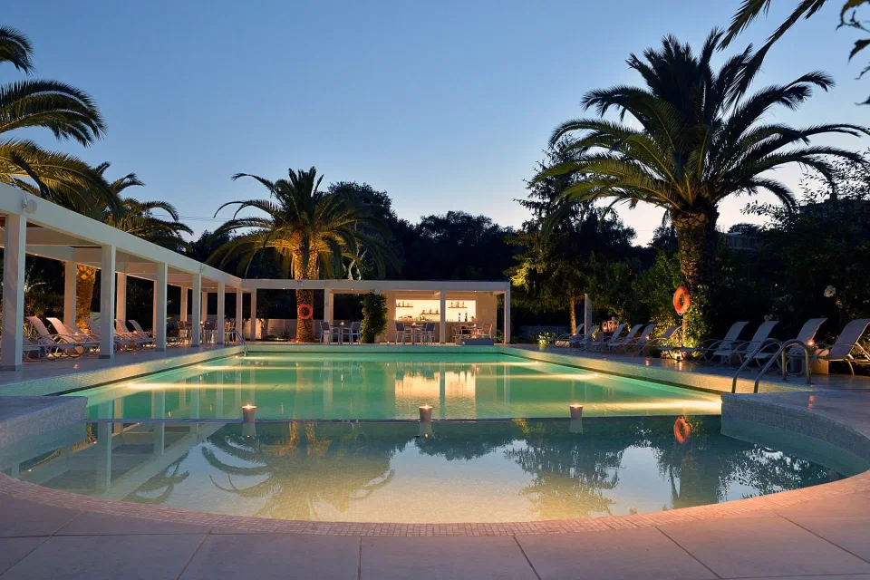 The illuminated outdoor pool and terrace at TRYP by Wyndham Corfu Dassia.