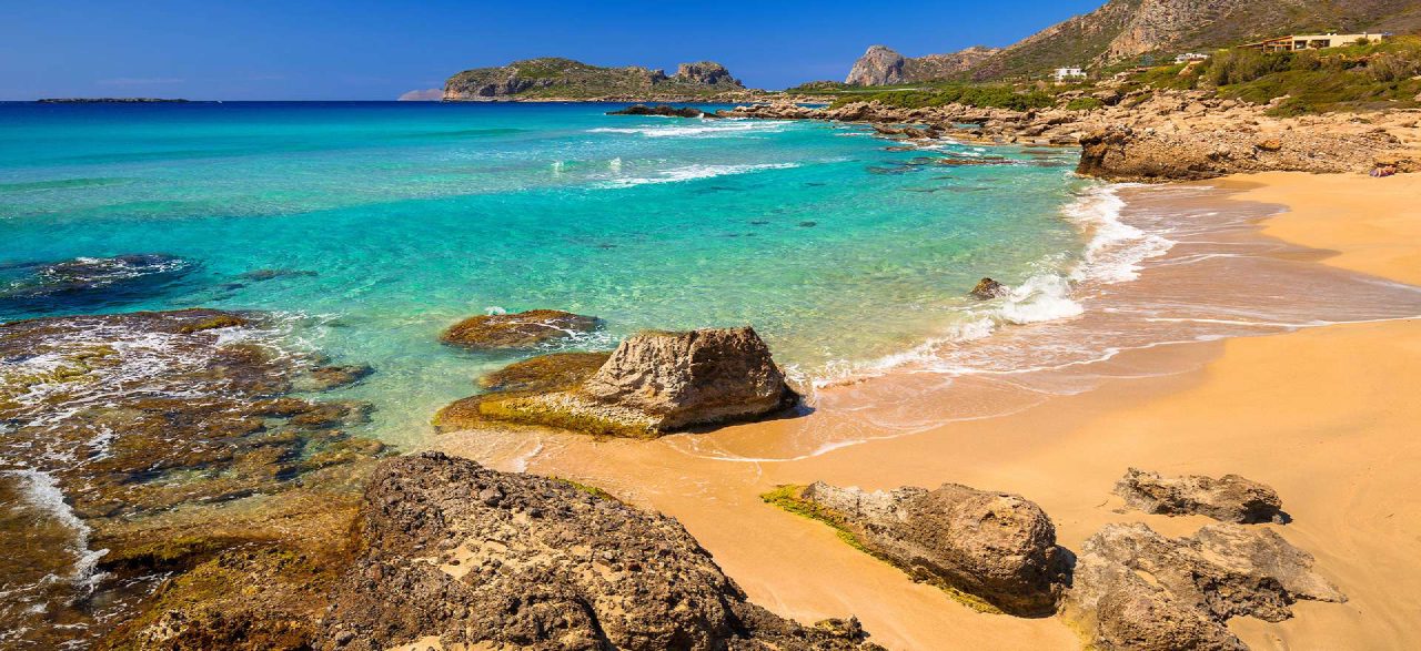 A sandy cove edged by rocks and turquoise water on the Falassarna coast.