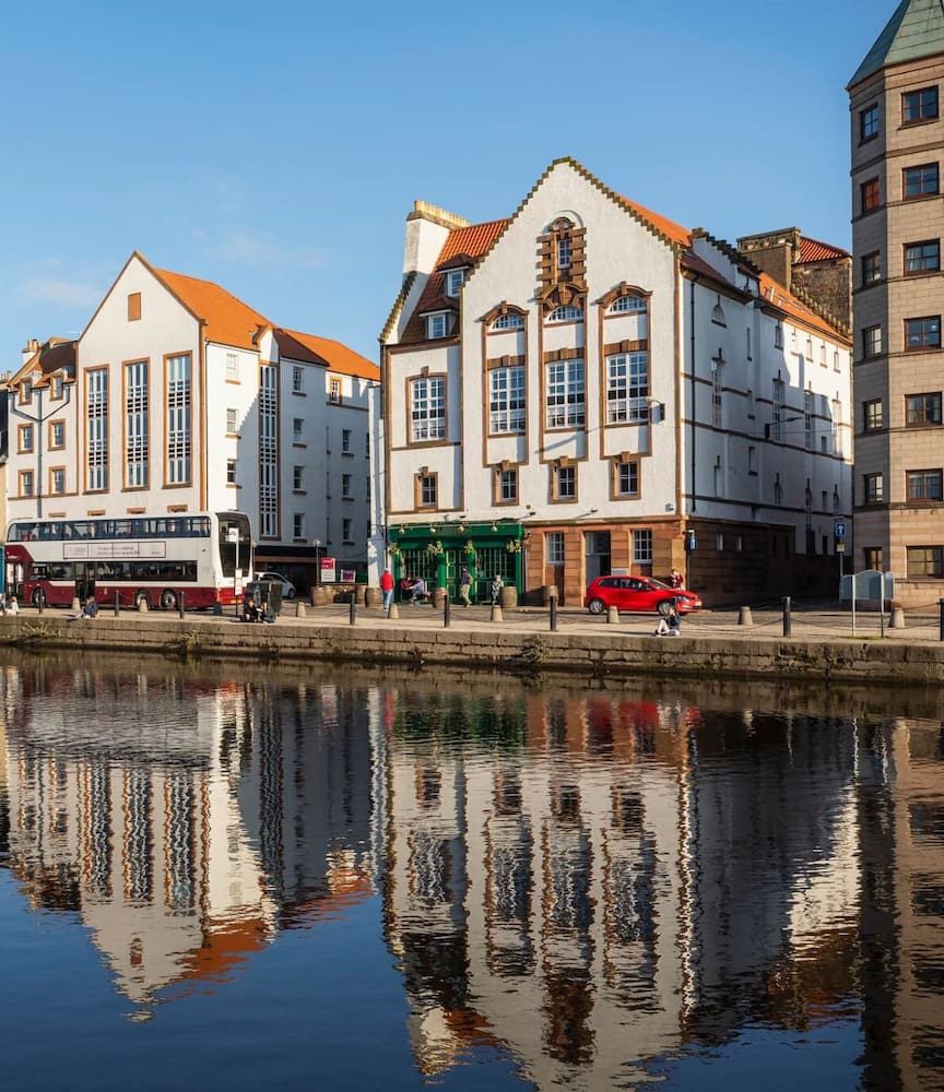 Buildings on The Shore reflected in the Water of Leith in Edinburgh.