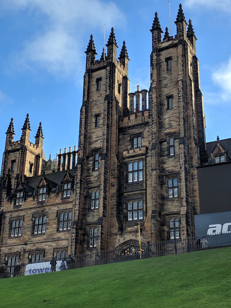 Twin towers of New College above the grassy slope of the Mound in Edinburgh’s Old Town.