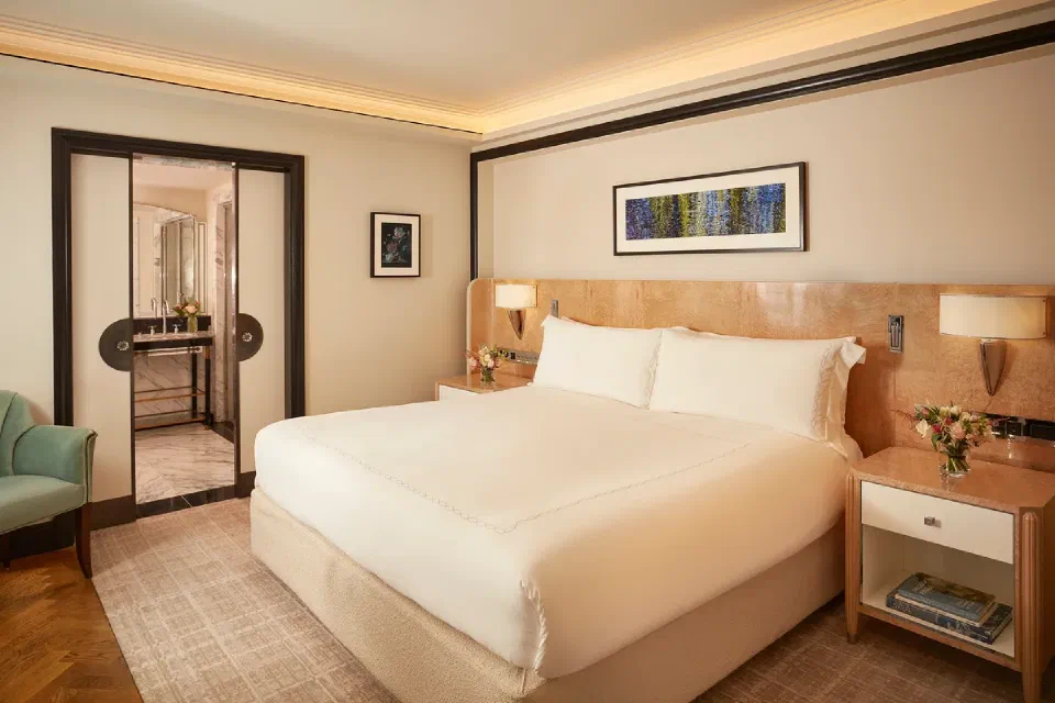 Superior Room at Claridge’s with a king-size bed, pale wood furnishings and an adjoining marble bathroom