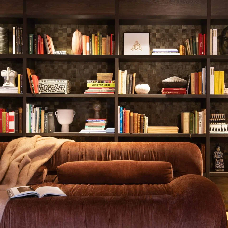 The library at Jan Luyken Amsterdam, with a brown sofa in front of full bookshelves.