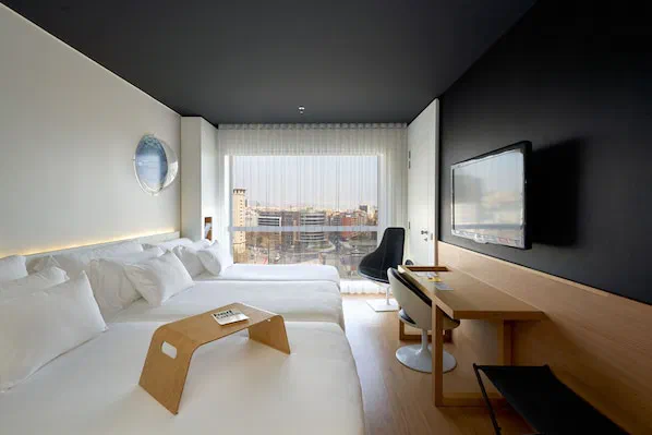 A twin bedroom at Barceló Sants with a desk beside the window.