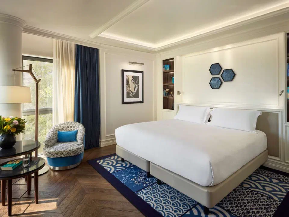 Premium-category bedroom at Sofitel Barcelona Skipper with a blue armchair.