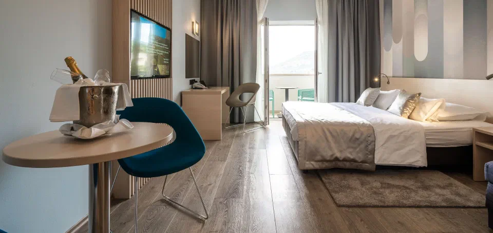 Guest room with a balcony and seating at Berkeley Hotel in Gruž.