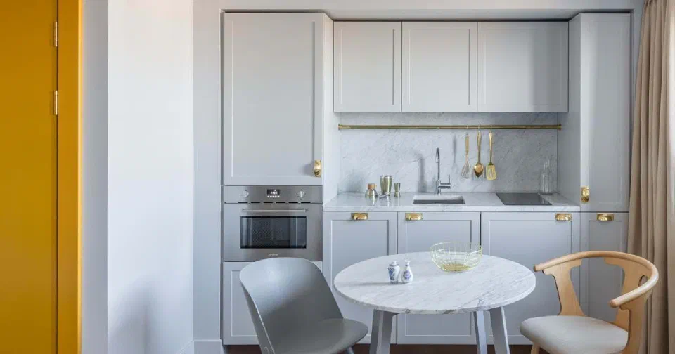 Pale-blue kitchen and round marble dining table in an Open Plan Suite at Eden Locke.