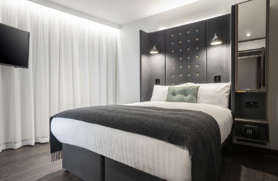 Compact double room with a dark headboard and grey bedcover at Point A Edinburgh Haymarket.