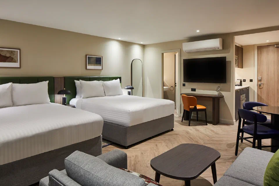 Two double beds, lounge seating and a dining table in a studio at Residence Inn Edinburgh.