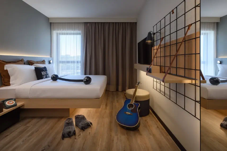 Queen bedroom with open storage at Moxy Lisboa Oriente.