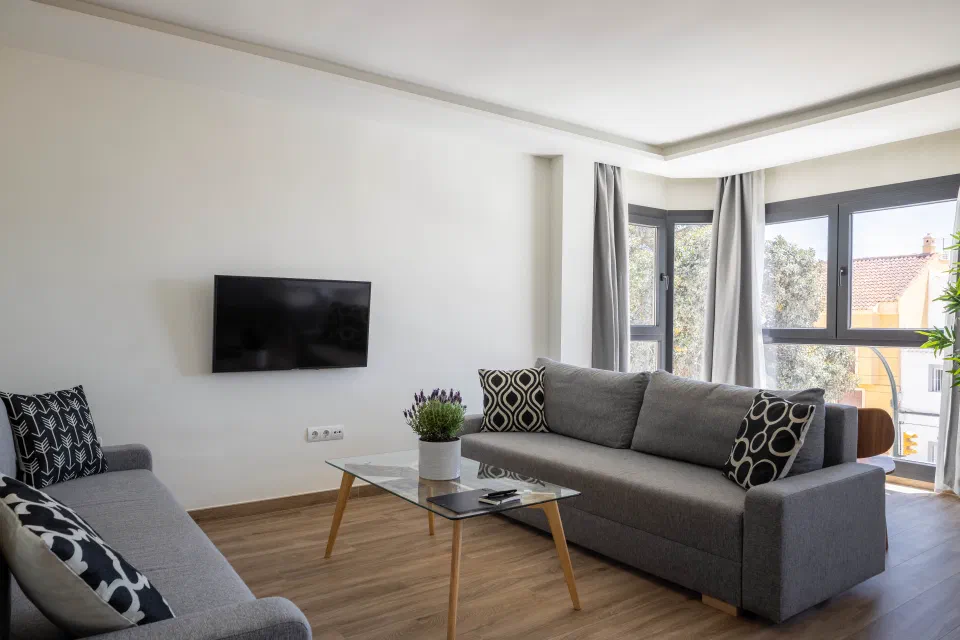 Bright living room with two sofas and corner windows in an Executive apartment at Be Mate Málaga Playa