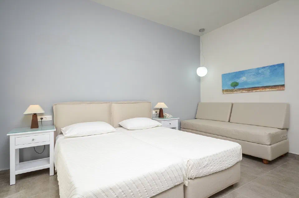 Hotel Grotta guest room with a large double bed and a sofa.