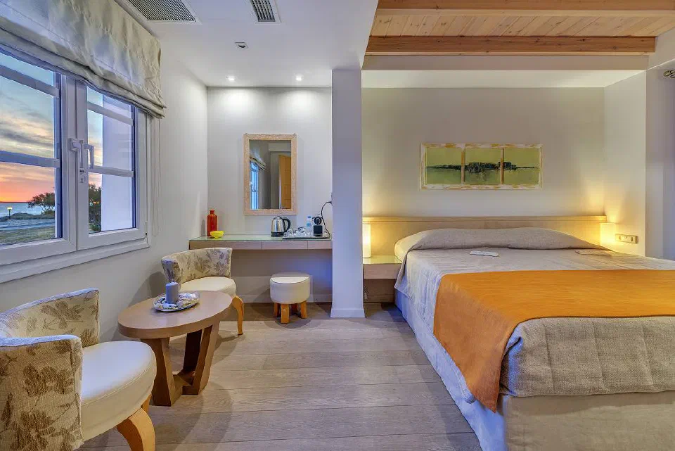 Nissaki One Bedroom Suite with a king bed, yellow cover and wooden ceiling.