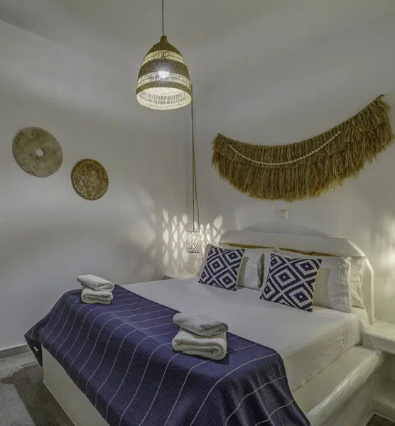 A Thalassa Naxos Superior Suite bedroom with a double bed and blue patterned cover.