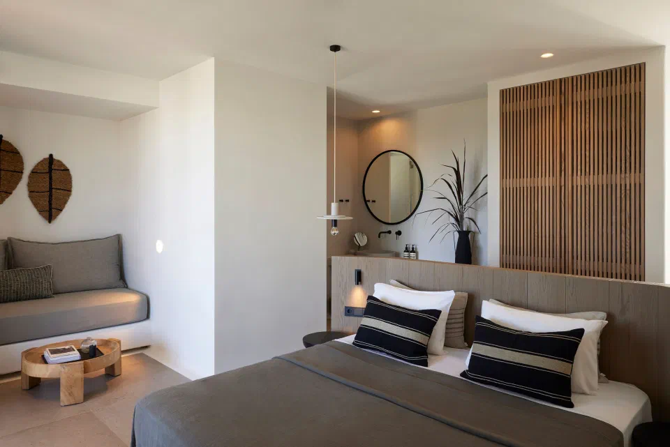 Cove junior suite interior with a bed, seating alcove and timber-screen details