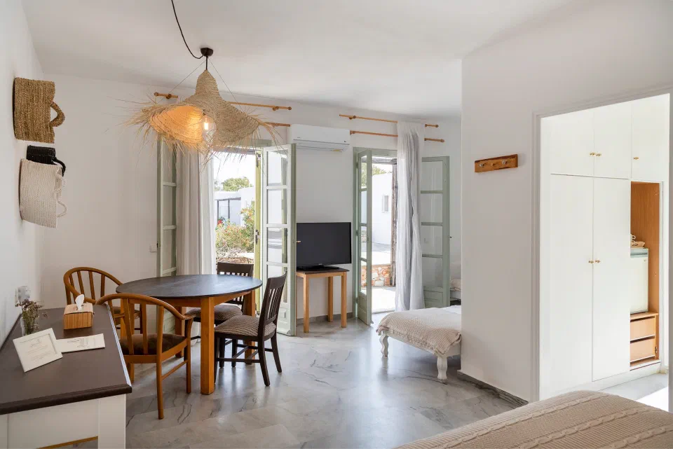 Parosland family room with a table, balcony doors and sleeping space in one room
