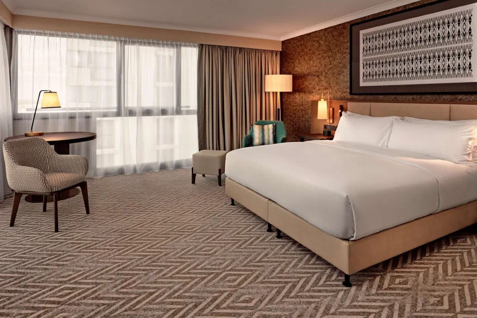 Hilton Vienna Park guest room with a double bed and a wide window.