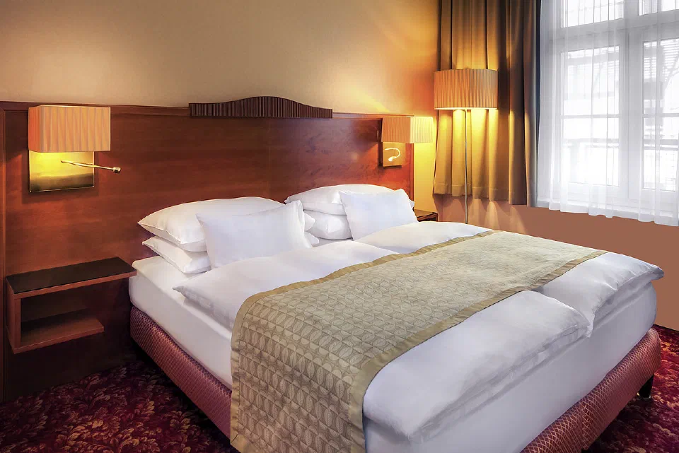 A Superior Wiener Elegance room at Hotel Josefshof with a sculpted wood headboard and a double bed.