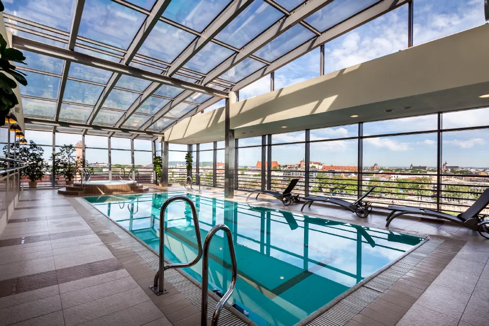 Glass-roofed top-floor pool and jacuzzi overlooking Kraków at Qubus Hotel.