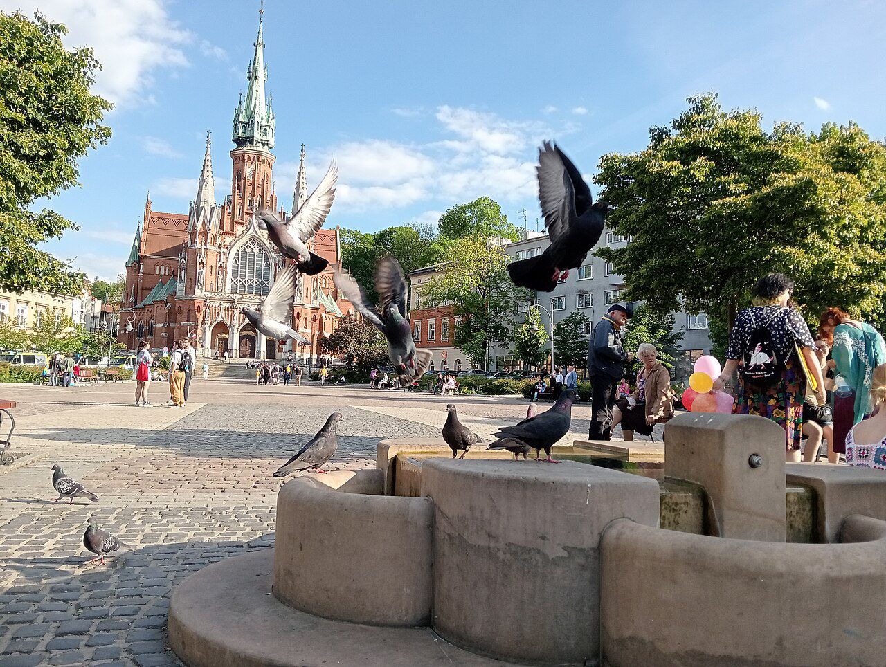 St Joseph’s Church beyond Rynek Podgórski, with pigeons in the foreground.