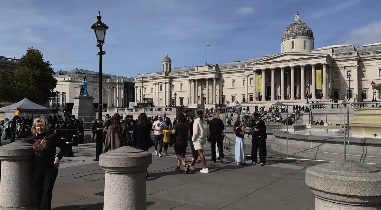People crossing Trafalgar Square in front of the National Gallery in London