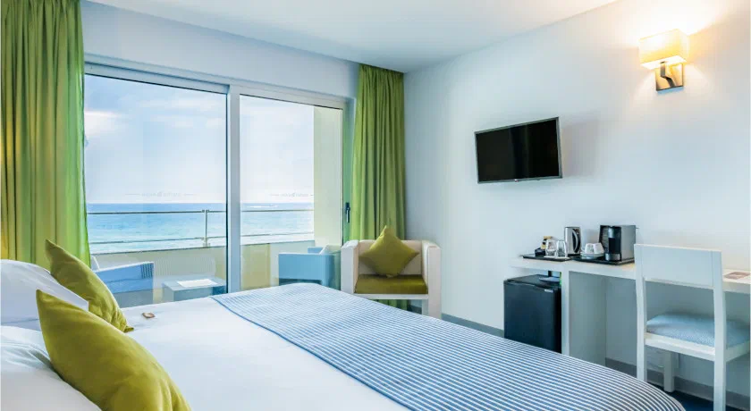 A double room at Aqua Natura Madeira with a balcony and the Atlantic beyond.