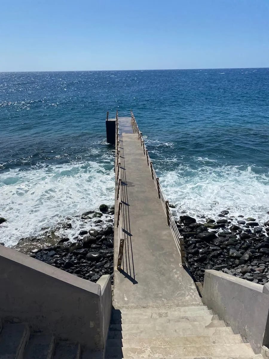 Steps and a pier leading down to the sea at Caniço de Baixo.