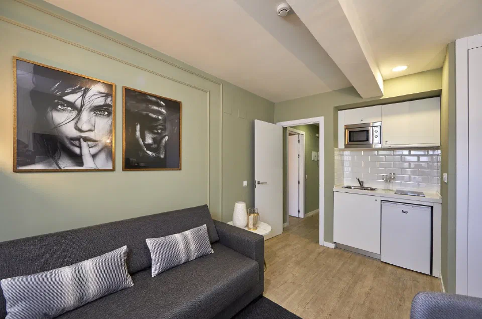 Lounge and fitted kitchen in a one-bedroom suite at L&H La Latina Selection.