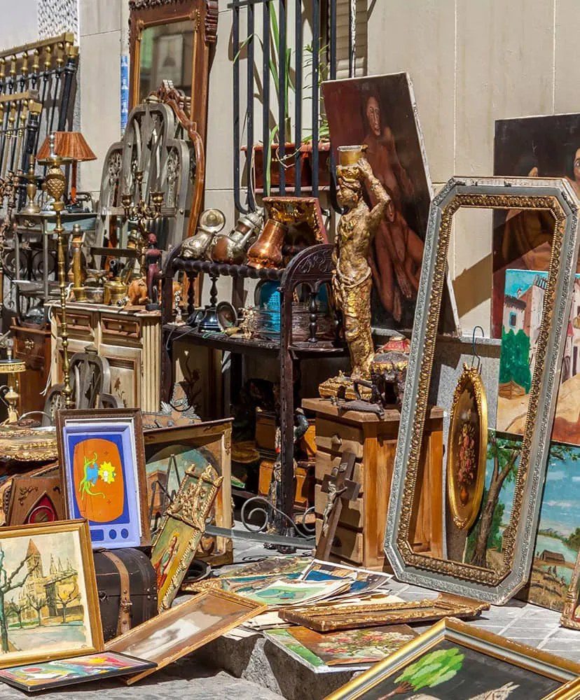 Antique mirrors, framed paintings and brass objects displayed at the Rastro.
