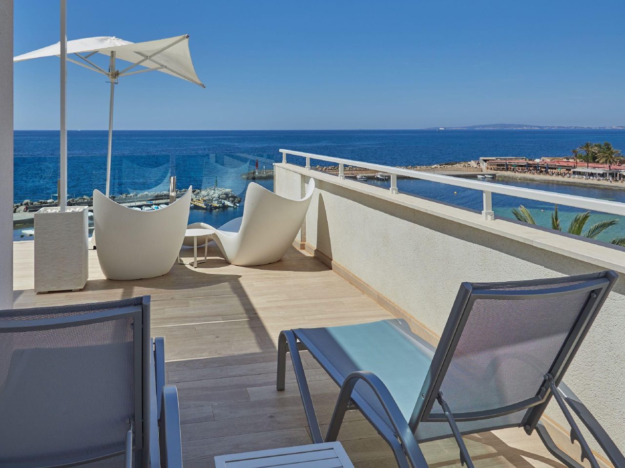 Cala Estància and its harbour wall seen from a furnished terrace at BQ Aguamarina in Can Pastilla.