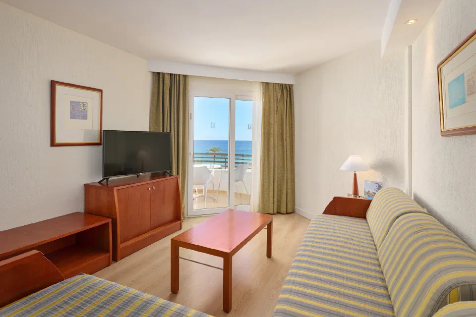 Living room with sofa beds and balcony in a Side Sea View 1 Bedroom Apartment at Hipotels Dunas Cala Millor.