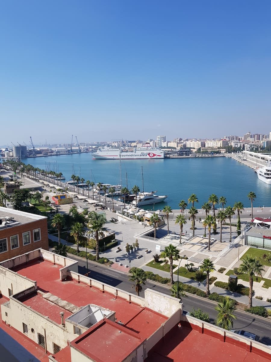 Málaga harbour and its palm-lined waterfront seen from above.