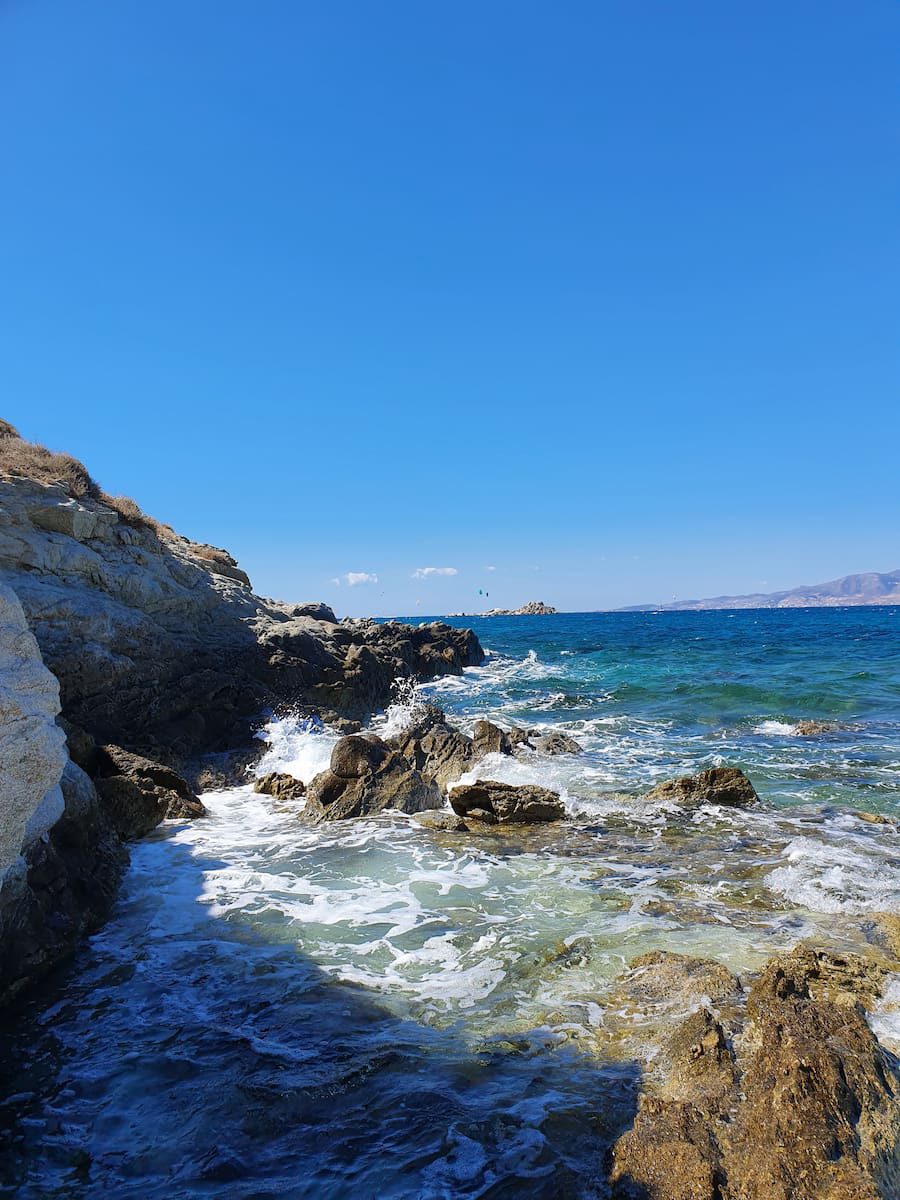 Granite rocks at Mikri Vigla, with meltemi-stirred sea and kites on the horizon