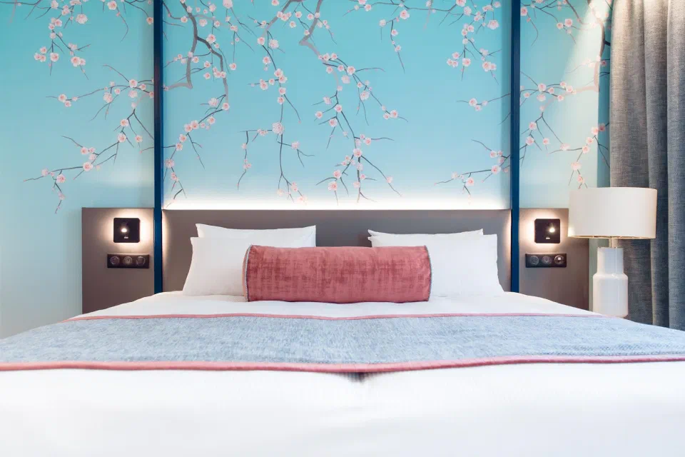 Executive double at Bleu de Grenelle with turquoise blossom wallpaper and a pink bed runner.