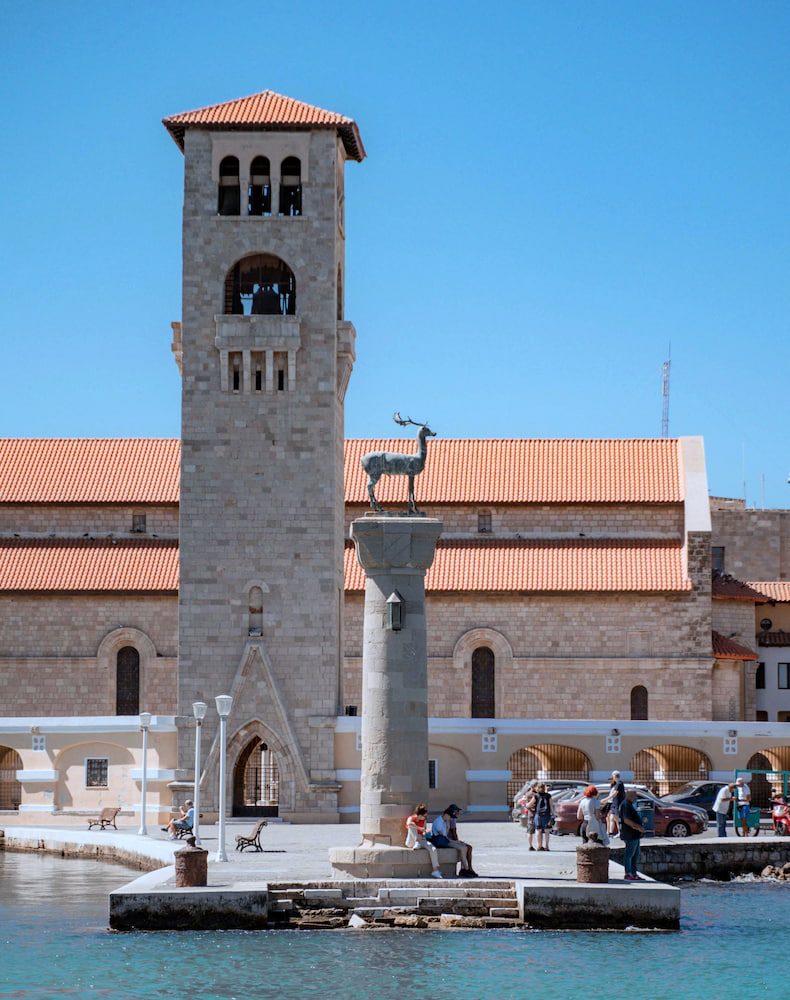 Evangelismos church and the deer-topped column beside the water at Mandraki harbour in Rhodes.