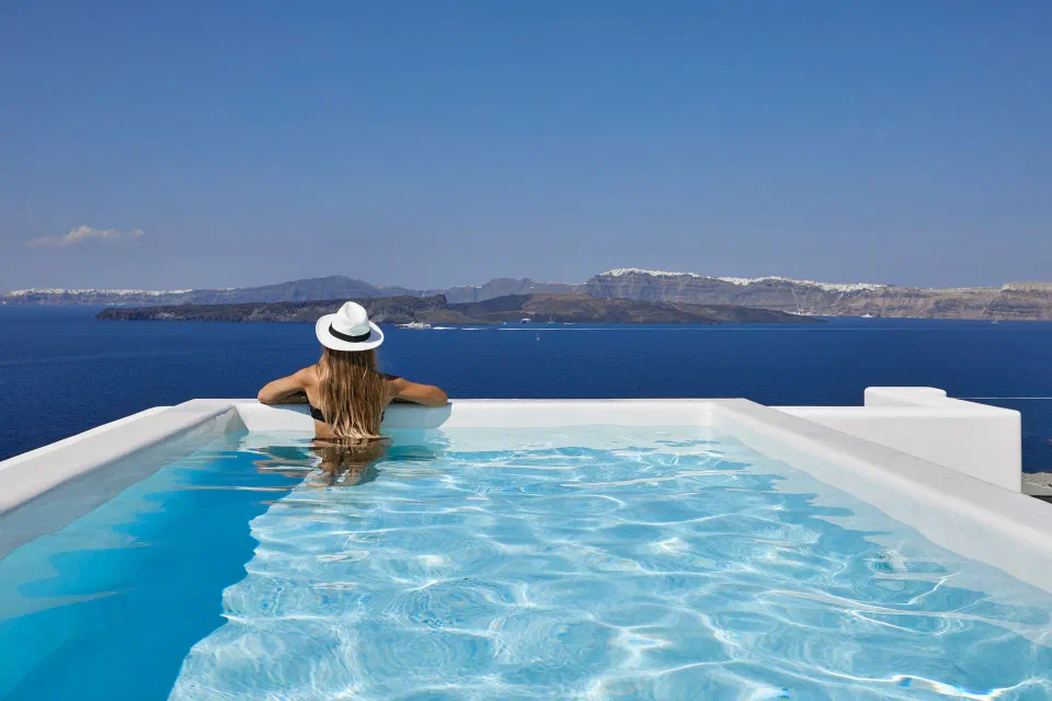 Person in the Prestige Suite private pool facing the caldera at Phōs The Boutique.