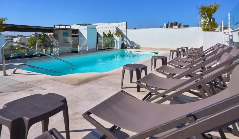 Rooftop swimming pool and rows of sun loungers at Hotel Bécquer in Seville.