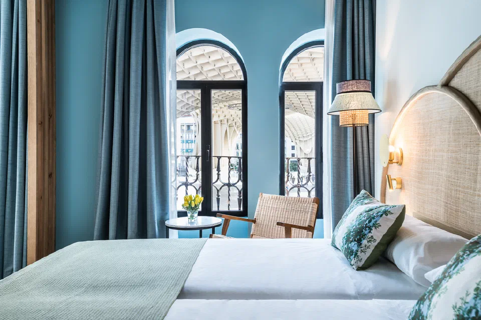 Deluxe room at Intelier Casa de Indias with the Setas visible through tall arched windows.