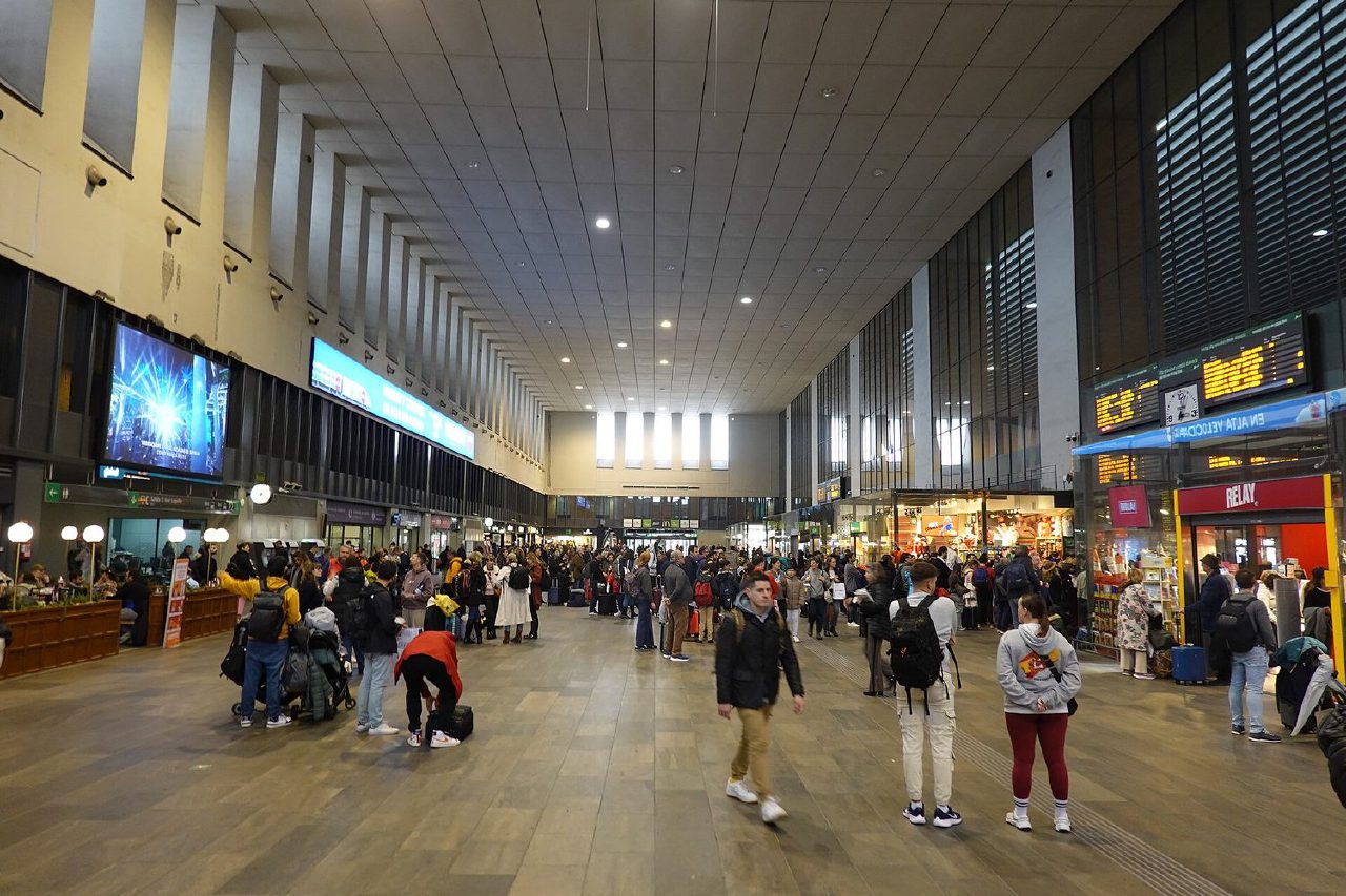 Travellers and departure boards in the concourse of Sevilla-Santa Justa station.