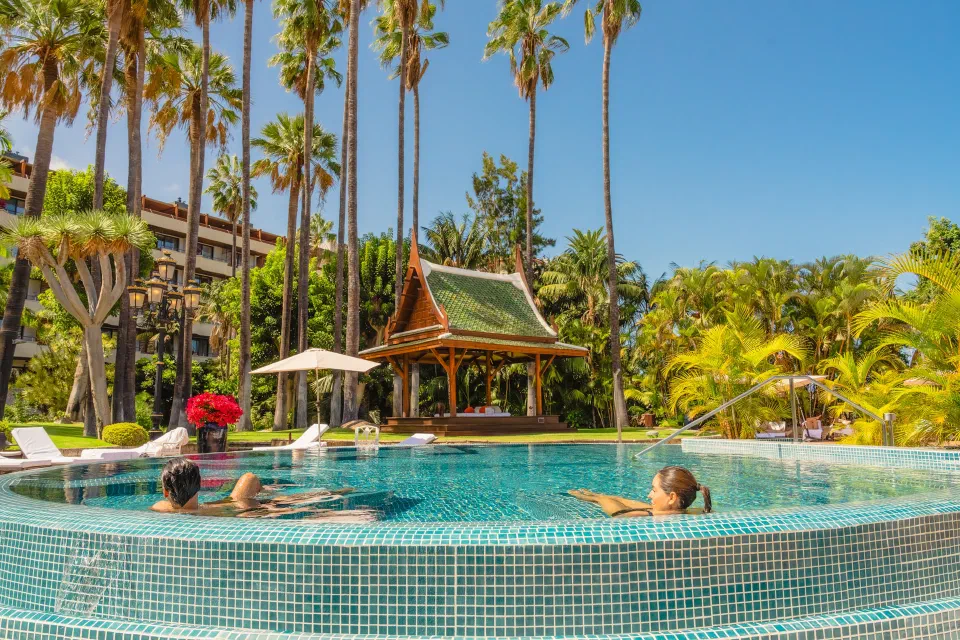 Palm-lined outdoor pool and Thai-style pavilion at Hotel Botánico in Puerto de la Cruz.