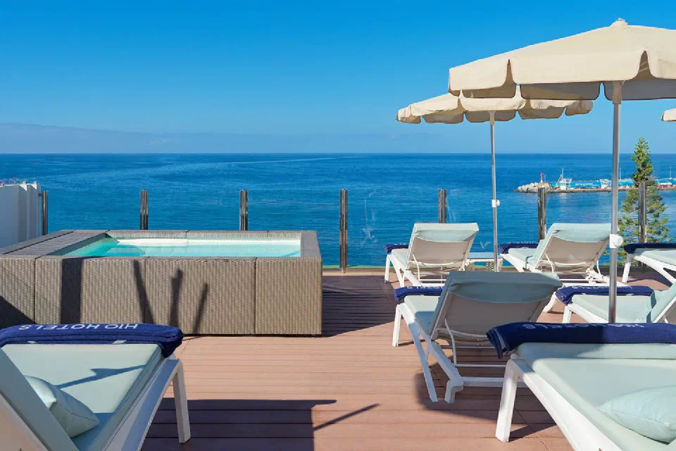 H10 Big Sur rooftop terrace with loungers and white parasols overlooking Los Cristianos harbour.