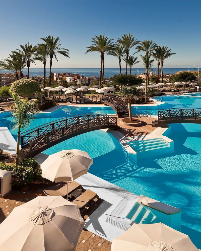 Resort pools and palms in Costa Adeje, with the Atlantic beyond.