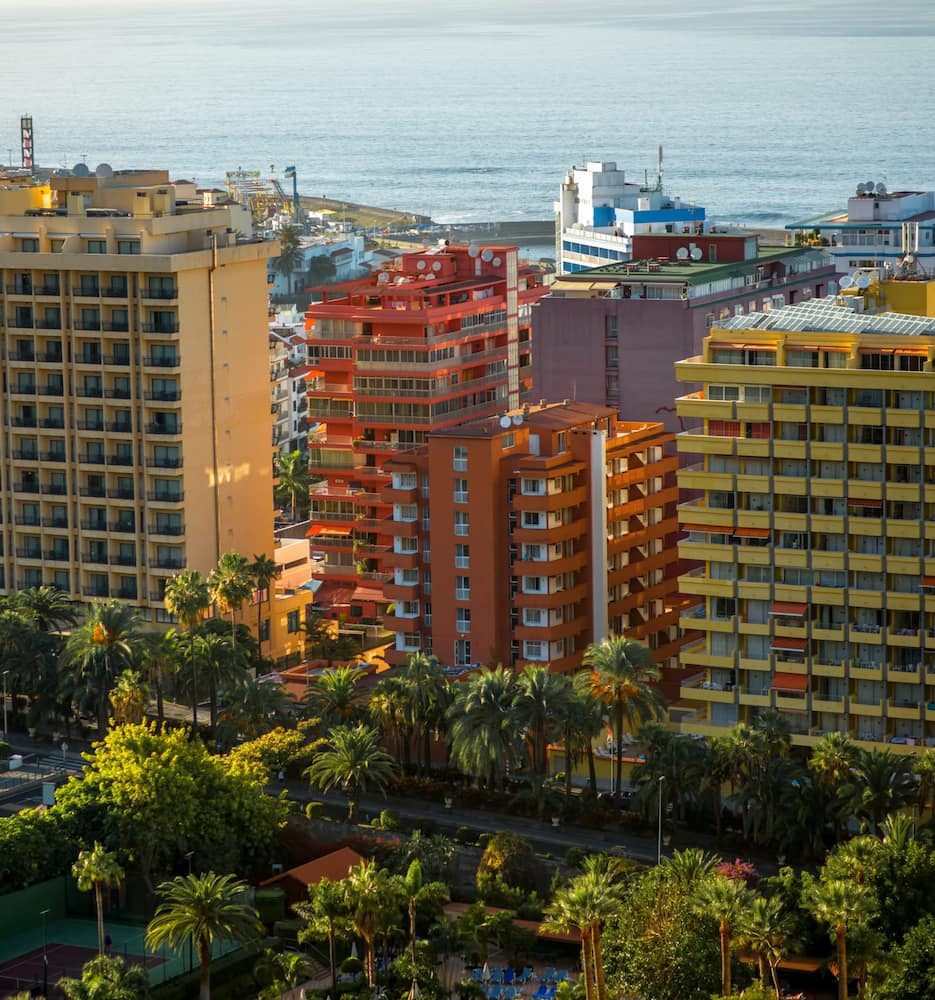 Pastel-coloured buildings and palms beside the Atlantic in Puerto de la Cruz.