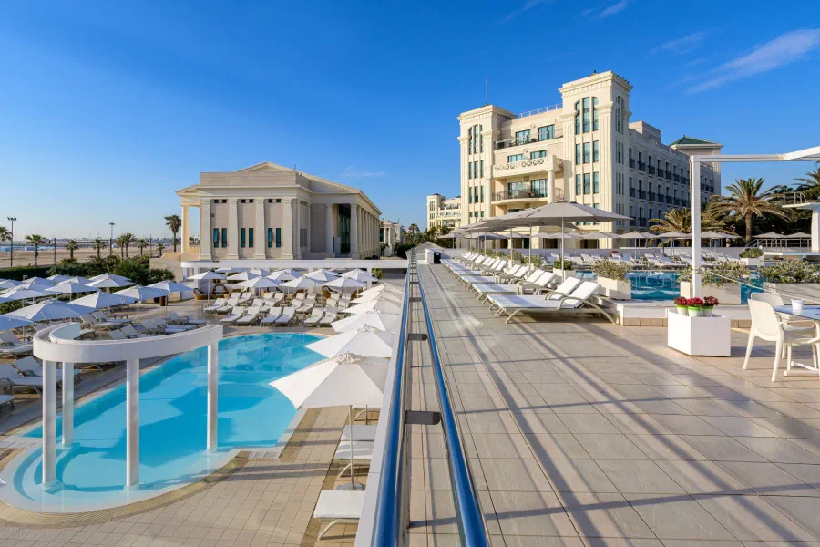 The outdoor pool terrace and loungers at Las Arenas Balneario Resort.