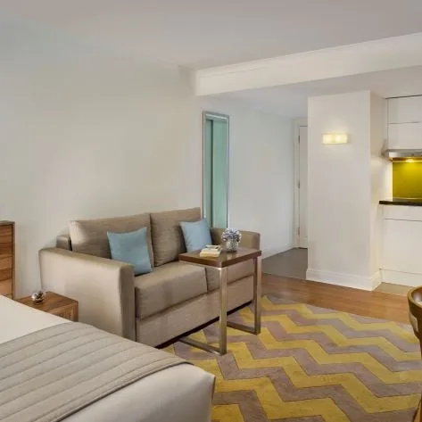 Studio Deluxe room at Citadines South Kensington London, with a double bed, sofa and kitchenette