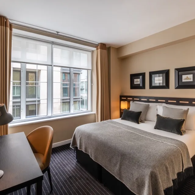 The Resident Victoria Standard Double room with a king bed, desk and large window
