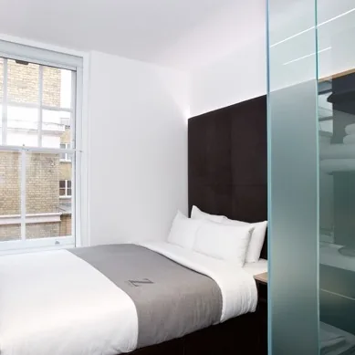 The Z Hotel Covent Garden Z Queen room with a bed, window and glass shower partition